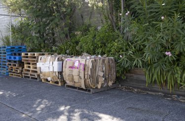 bales of cardboard outside on ground