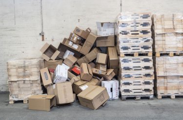 cardboard waste in pile between pallets